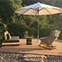 Die Holzterrasse mit Lounge-Möbeln und Sonnenschirm hat schon beim Hinschauen entspannenden Charakter. Wenn die Sonne am Abend die Essterrasse schattiert, kann man auf der Holzterrasse noch die letzten Sonnenstrahlen bis zum Untergang einfangen. Der Sonnenschirm mit seiner speziellen Fußhalterung kann bei Bedarf mühelos versetzt werden.