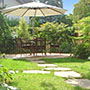 Der Blick in den Garten: der runde Sitzplatz aus Natursteinplatten ist der zentrale Blickfang.