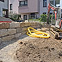 Die erste Mauer ist gesetzt. Die Mauerhöhen der einzelnen Terrassen wurden planerisch so gerechnet, dass keine Absturzsicherungen erforderlich sind. Wenn Kinder im Garten sind, ein wichtiges Kriterium.