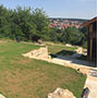 Blick von der neuen Sitzterrasse: ein schöner Blick auf den Garten und in das Tal. Der Rasen ist erst frisch eingesät und braucht noch etwas Zeit, um die Fläche komplett zu schließen.